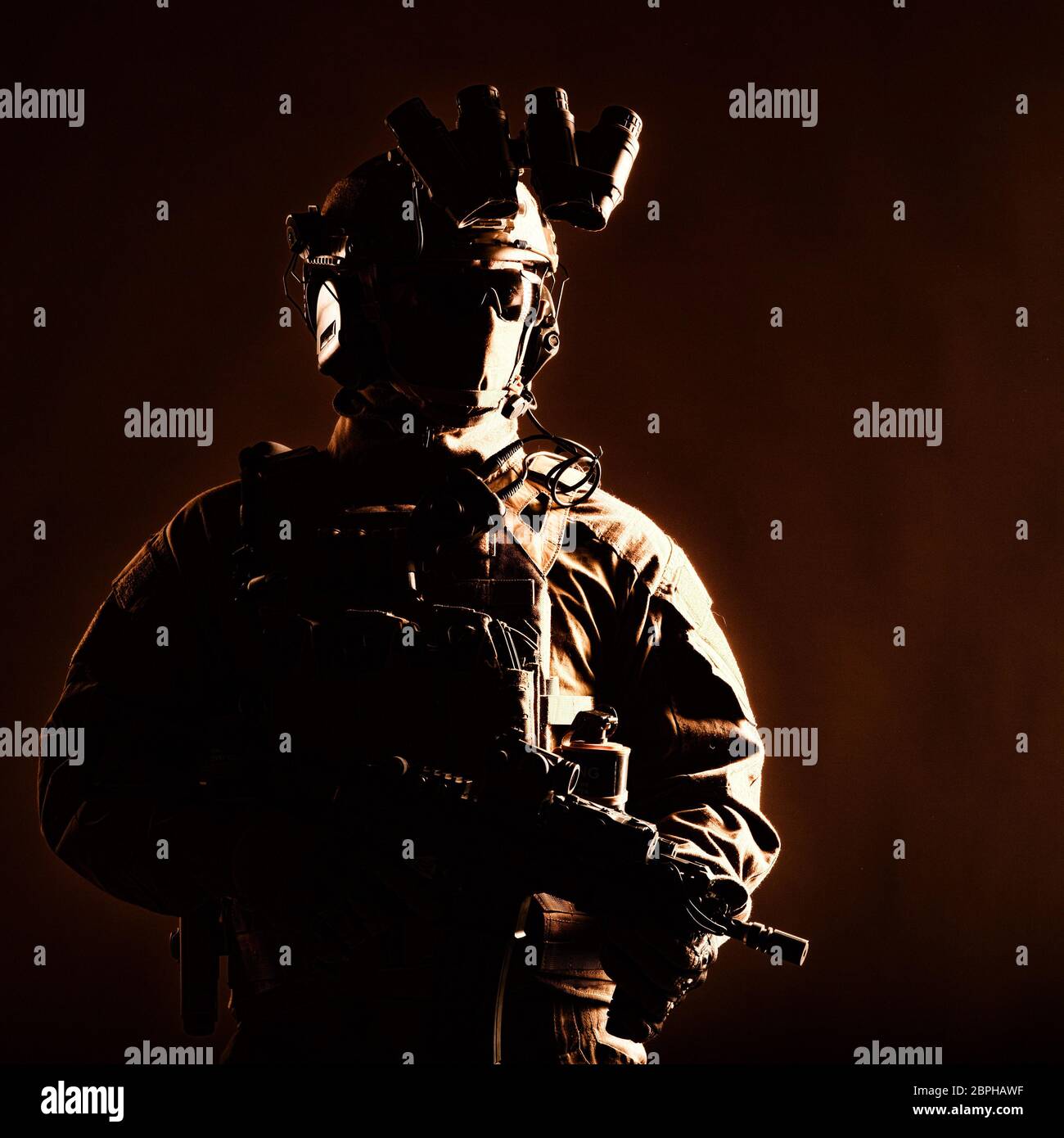 Armee Elite Forces Mitglied, modernen Infanteristen mit versteckten Gesicht, in dem taktischen Munition, ausgestattet radio Headset, nachtsichtgerät am Helm montiert, Stockfoto