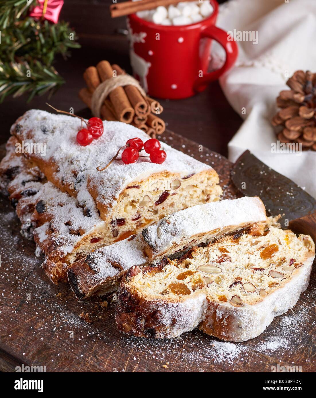 Stollen eine traditionelle europäische Kuchen mit Muttern und kandierten  Früchten, mit Puderzucker bestäubt und in kleine Stücke schneiden auf  braunem Holz- Board Stockfotografie - Alamy