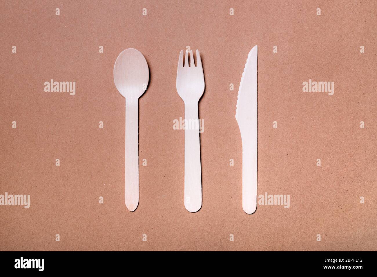 Set aus Bambus-Besteck aus Holz: Gabel, Messer und Löffel auf Naturpapier Hintergrund. Stockfoto
