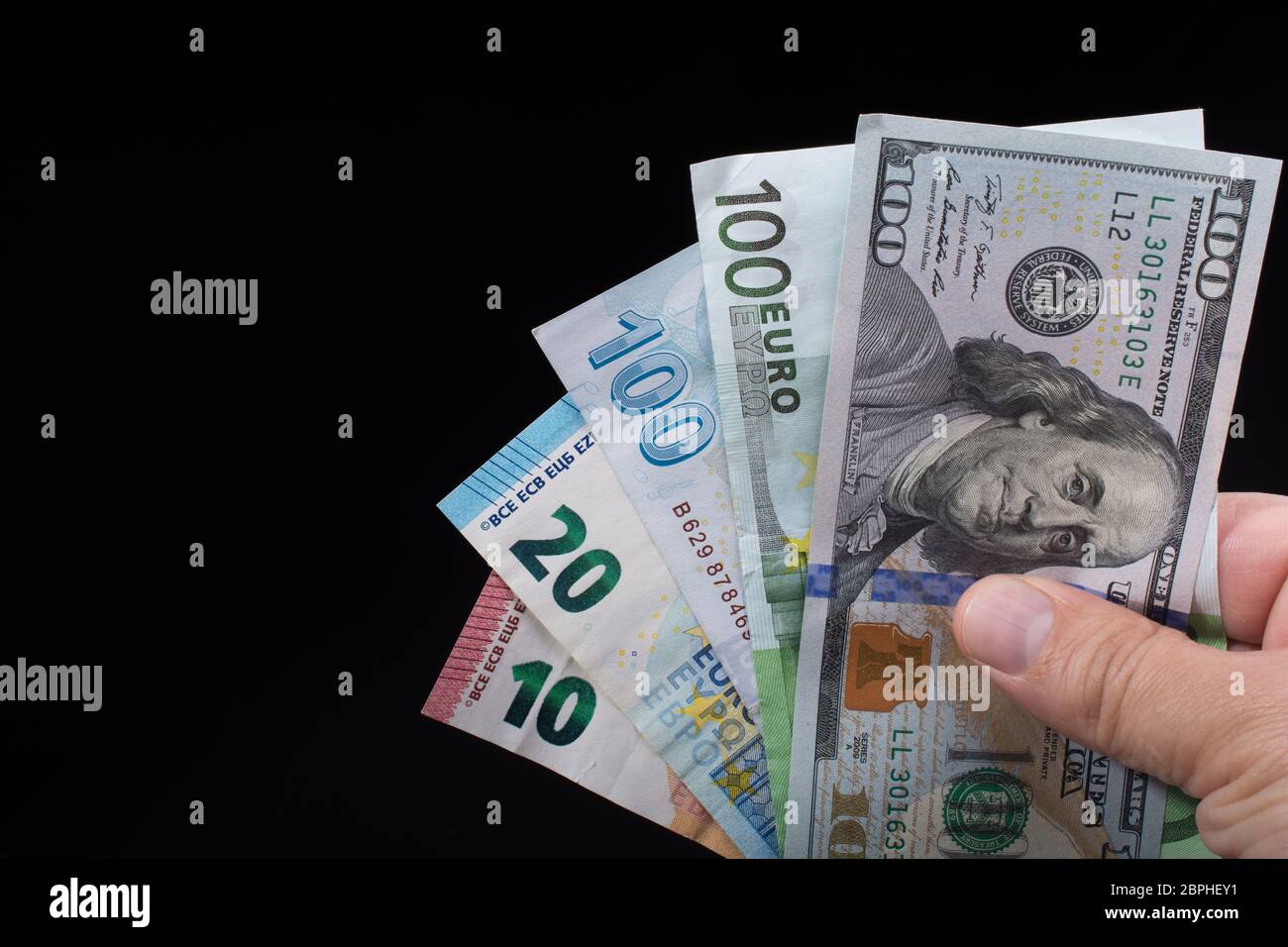 Hand mit amerikanischen Dollar Banknoten auf schwarzem Hintergrund Stockfoto