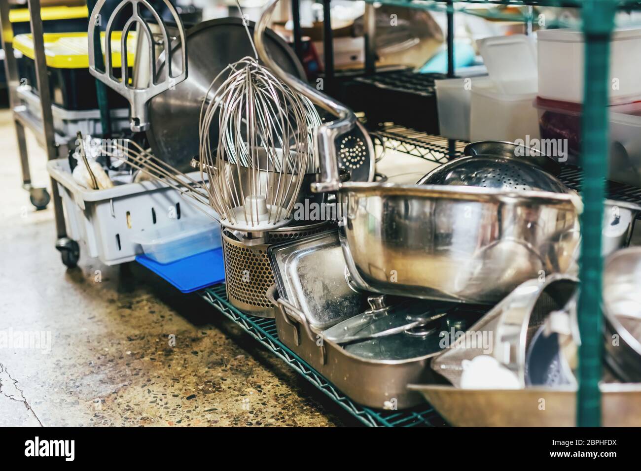 Küchenutensilien auf Regalen in einer Industrieküche. Stockfoto