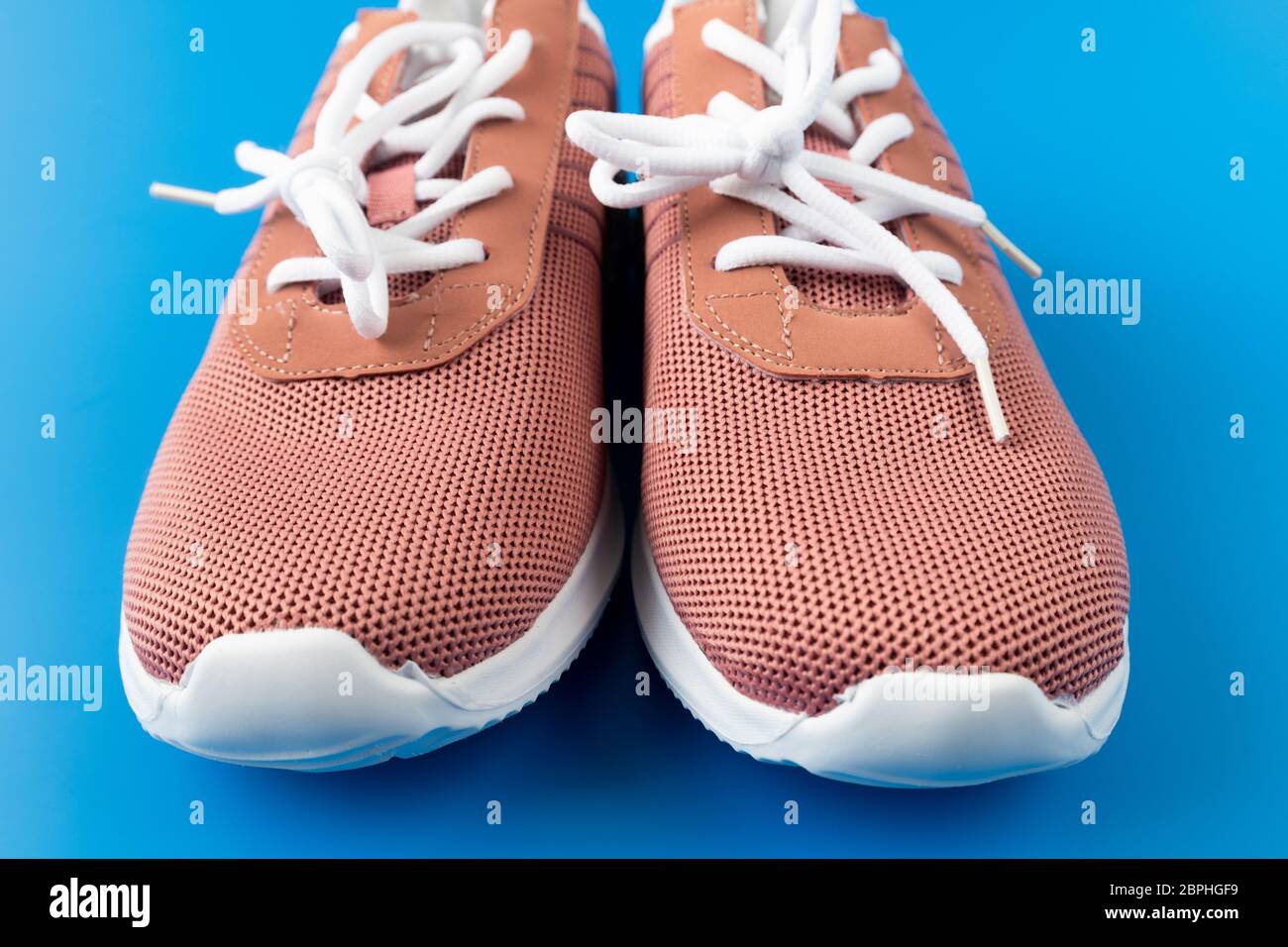 Braune Textil-Sneakers auf blauem Hintergrund. Stockfoto