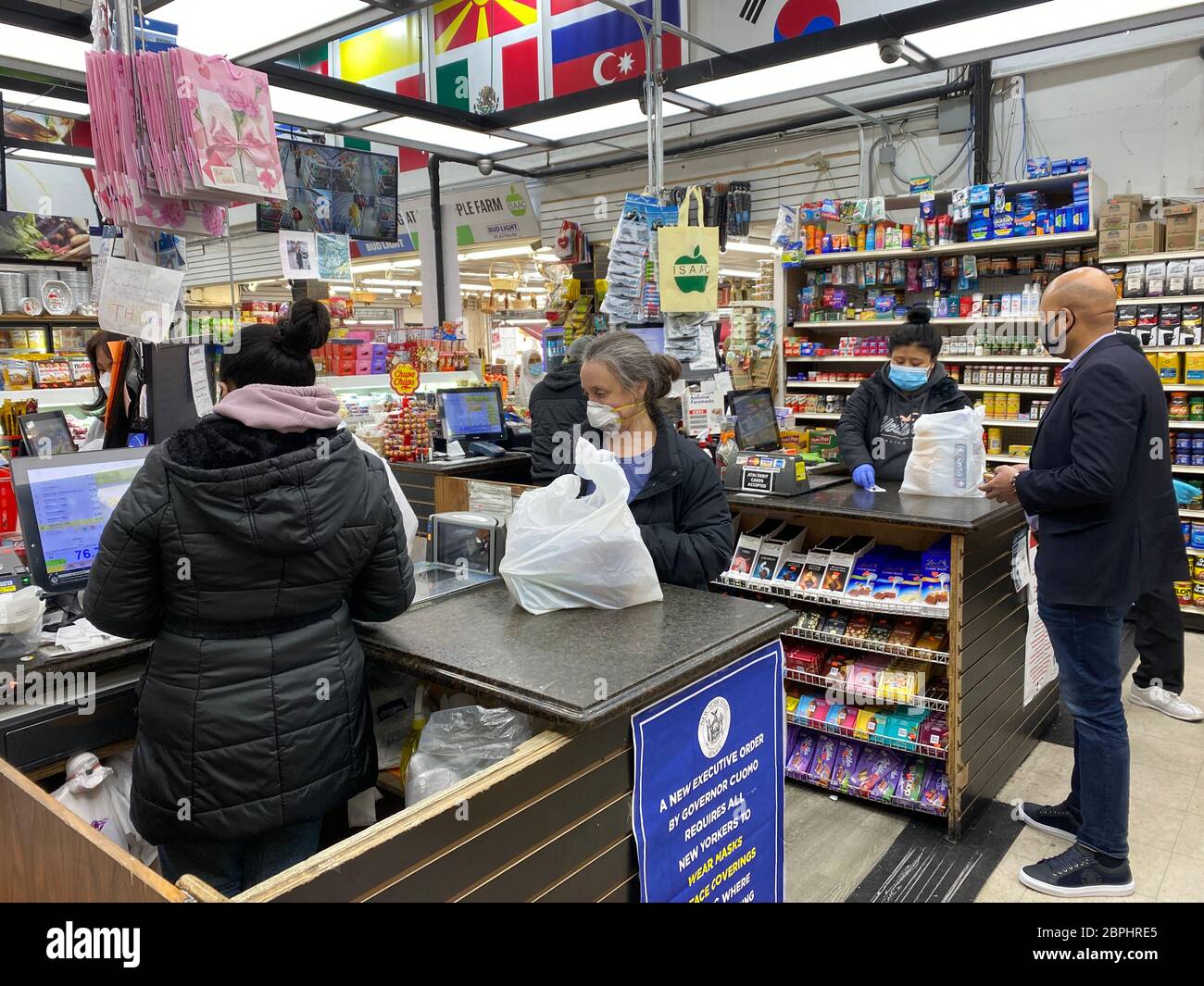 Während der Pandemie von Covid-19 im Stadtteil Kensington in Brooklyn, New York, kaufen Menschen auf einem Nachbarschaftsmarkt Lebensmittel ein. Stockfoto
