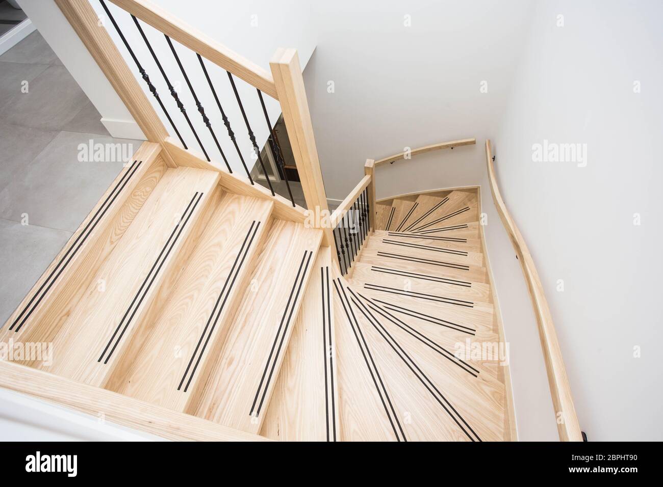 Luxuriöse moderne Holztreppe mit geschwungener Landewand in modernem Design Stockfoto