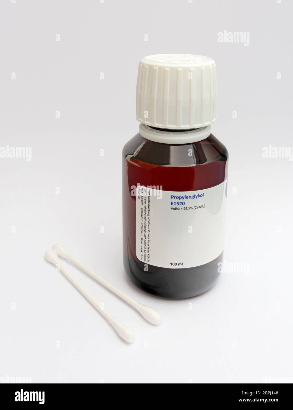 n-Propanol in dunkler Glasflasche und Wattestäbchen zur Desinfektion. Isoliert auf weißem Hintergrund Stockfoto