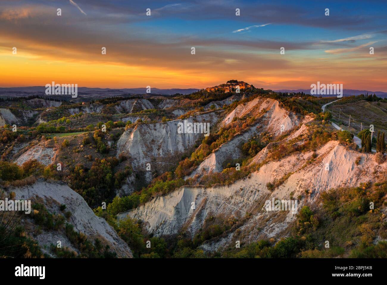 Das Hämchen von Chiusure, das auf den beeindruckenden Klippen nahe der Abtei Monte Oliveto ragt, schoss in einer goldenen Herbststunde Stockfoto