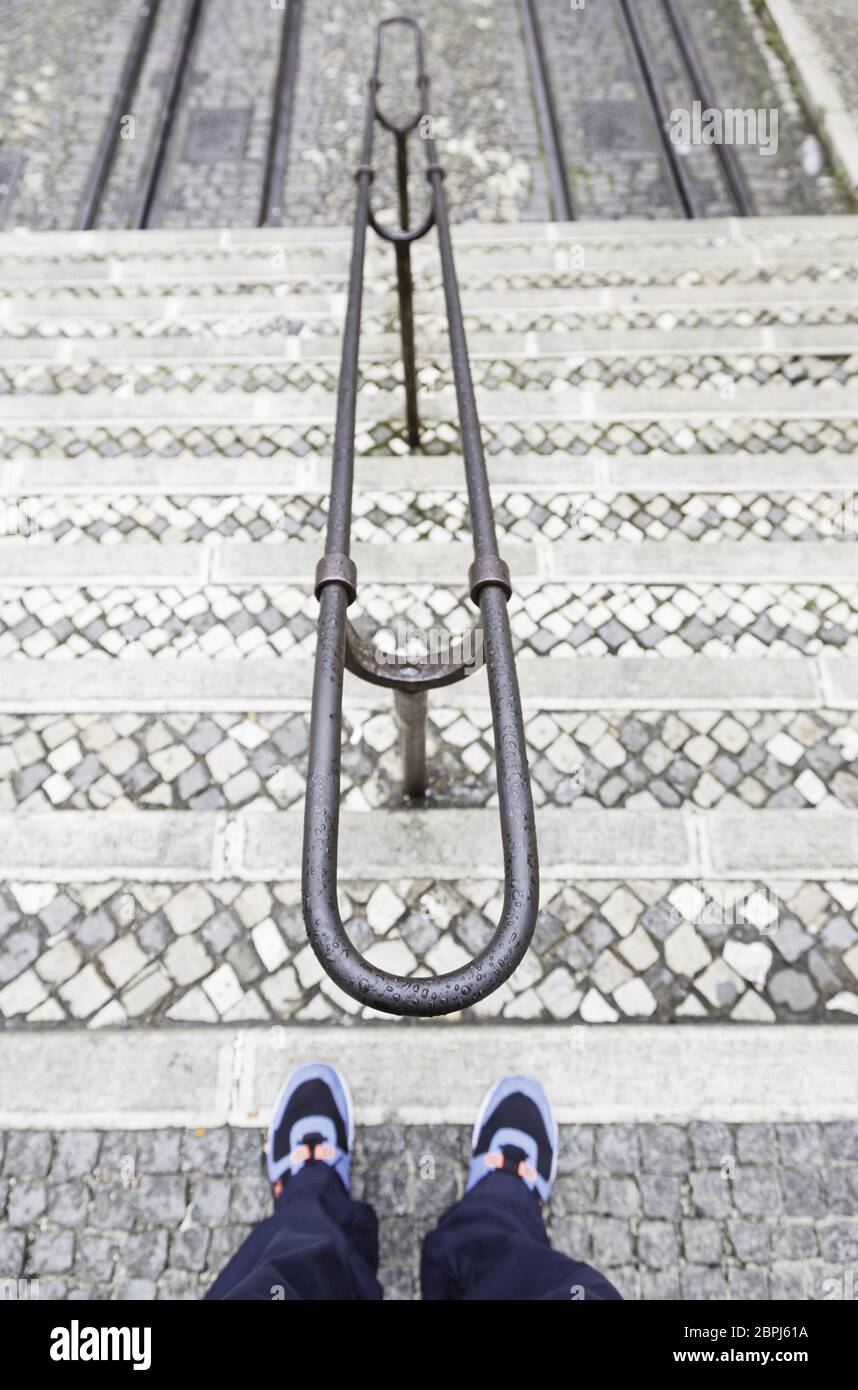 Alte nasse in der Stadt, Detail der Füße auf dem Boden der Treppe Leiter Stockfoto
