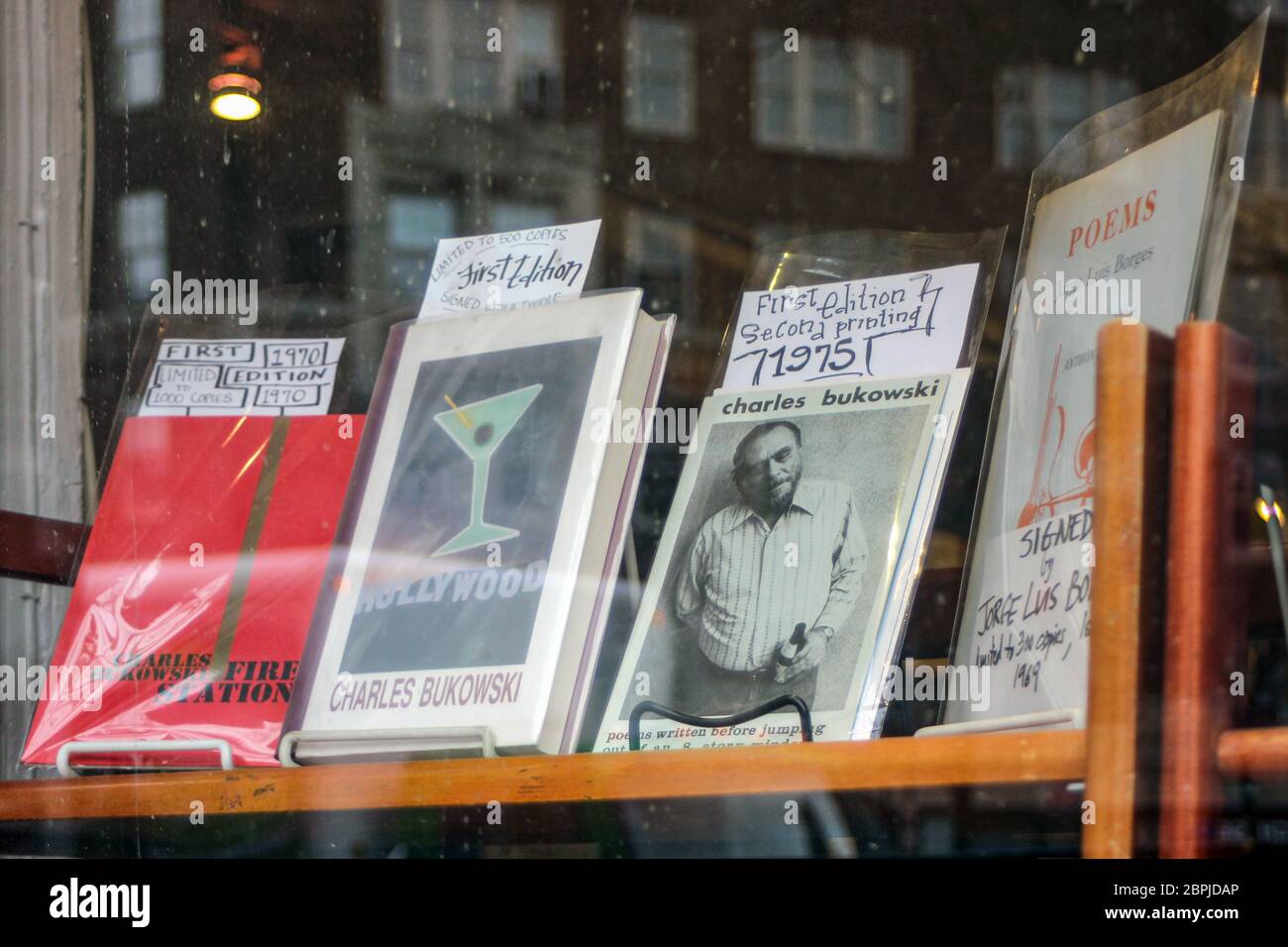 Seltene Ausgaben von Charles Bukowski-Büchern in einem Second Hand-Buchladen-Schaufenster in Manhattan, New York City, Vereinigte Staaten von Amerika Stockfoto