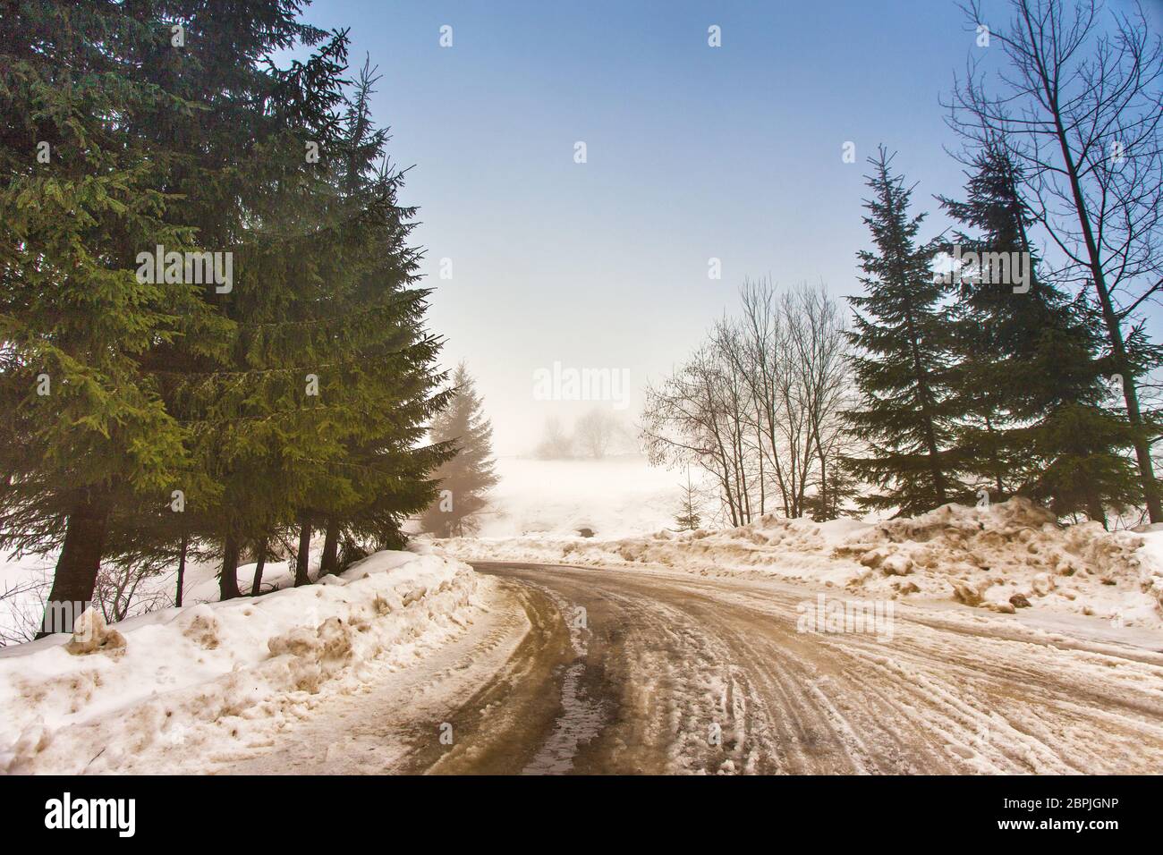 Schmelzender Schnee auf dem Berg Landstraße in den Karpaten. Wettervorhersage für frühen Frühling. Schwieriger Weg. Der frühe Frühling im gemäßigten Klima. Feder kom Stockfoto