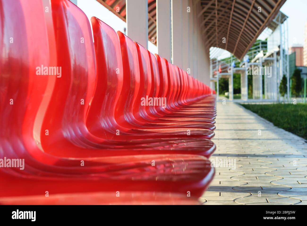 Rote Plastiksitze im Stadion Stockfoto