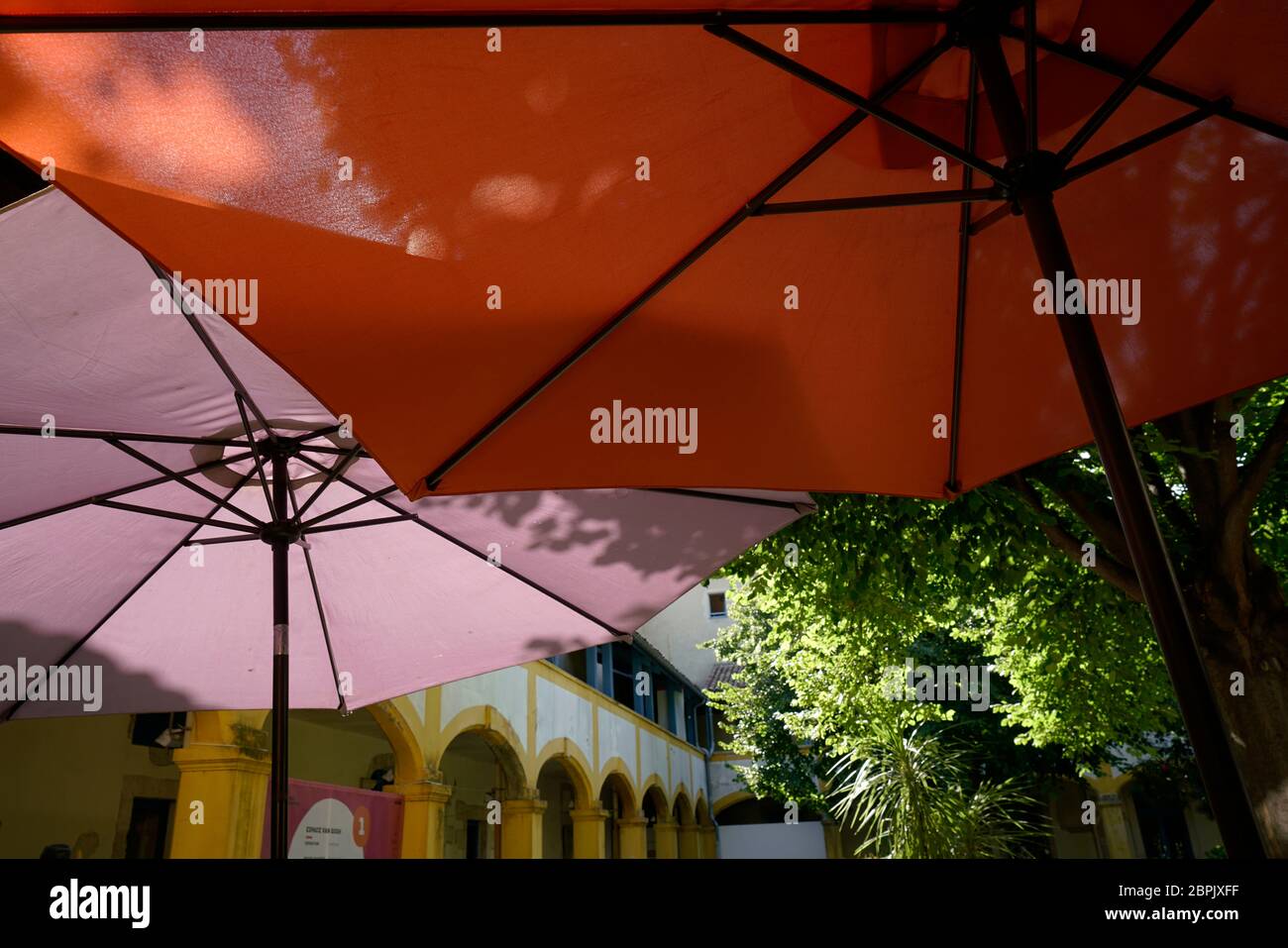 Bunte Regenschirm im Garten von Espace Van Gogh Kulturzentrum, ehemaliges Krankenhaus, Arles, Bouches-du-Rhone, Provence-Alpes-Cote d'Azur.Frankreich Stockfoto