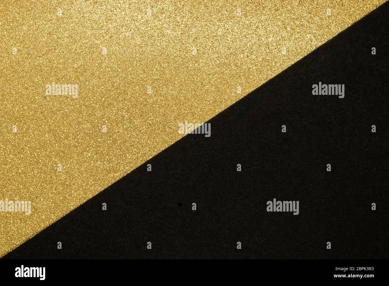 Abstrakter Hintergrund aus goldenem glänzend und schwarzem Bastelpapier in der Hälfte geteilt machen Dreieck Form Stockfoto