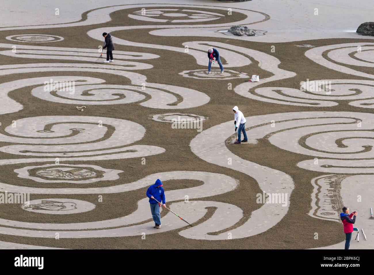 Bandon by the Sea, Oregon / USA - Februar 21 2020: Das Team von Circles in the Sand zeichnet ein begehbares Labyrinth im flachen Sandstrand von Face Rock Stockfoto