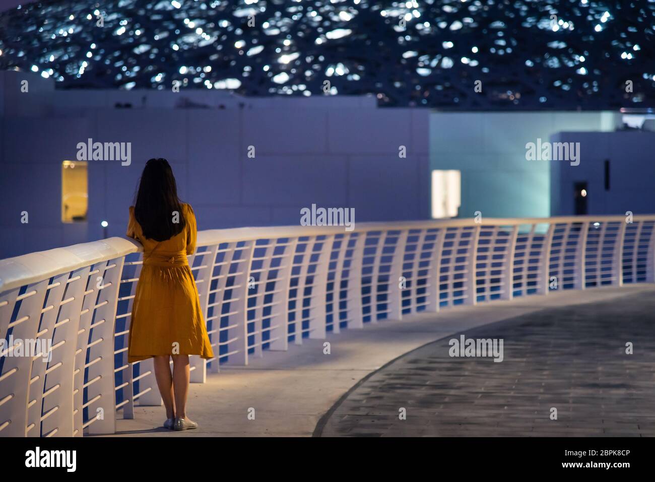 Abu Dhabi, Vereinigte Arabische Emirate - 20. November 2019: Frau besucht Louvre Museum in Abu Dhabi Außen-und Eingang mit charakteristischen Architektur Stockfoto