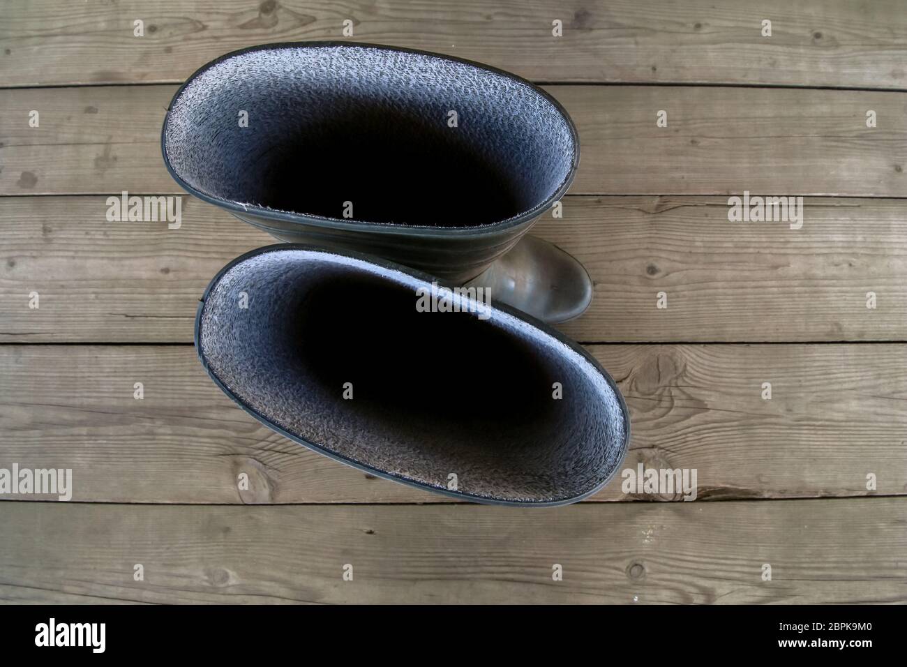 Gummistiefel auf dem Holzboden. Abstract background Image. Blick von oben. Blick von oben auf die Landwirt Gummistiefel stehen auf Holzboden Stockfoto