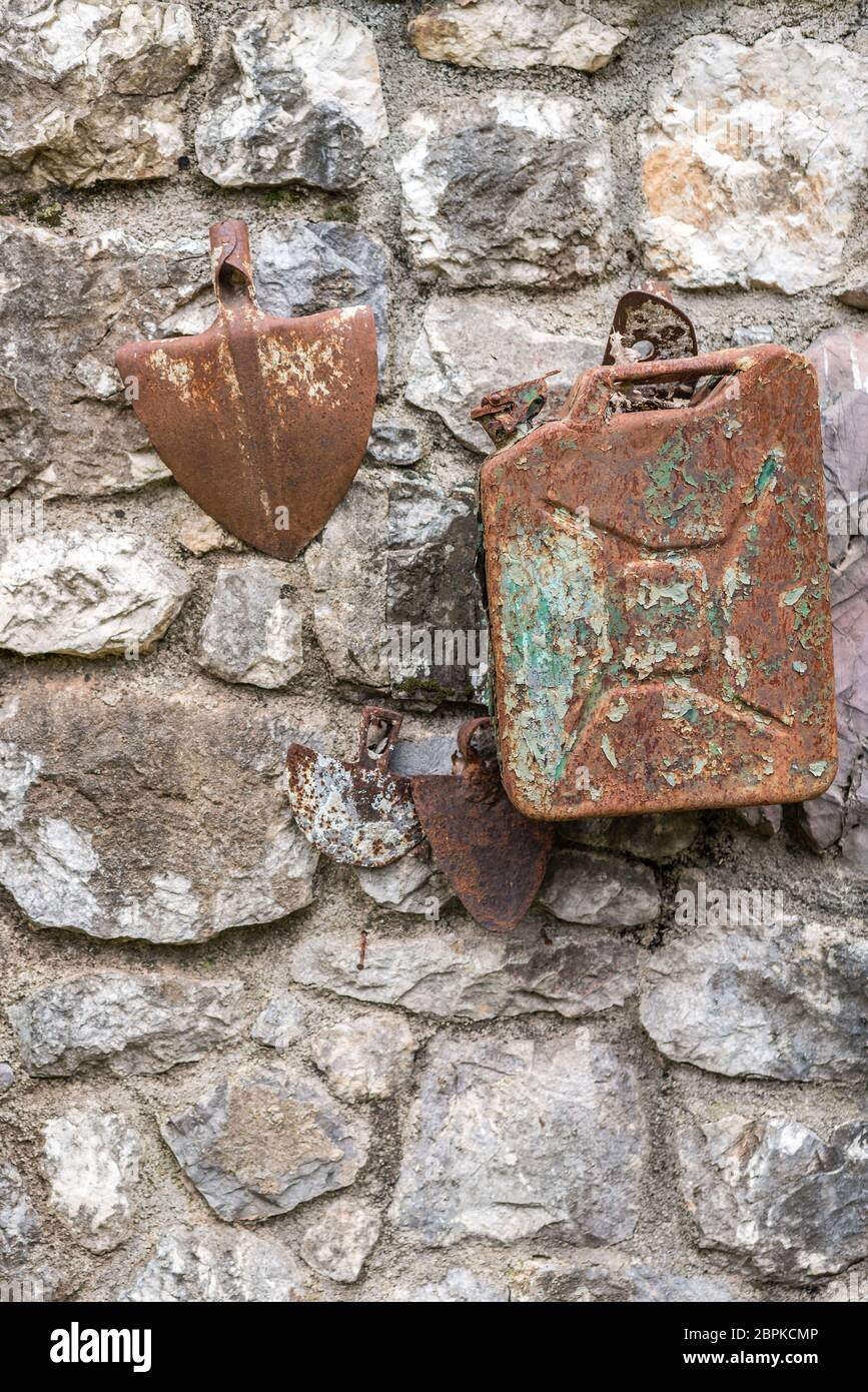 Alte verfallende Rusty benzin Kanister und Schaufel Kopf an der Wand eines  Gebäudes in einer Landschaft verbunden Stockfotografie - Alamy