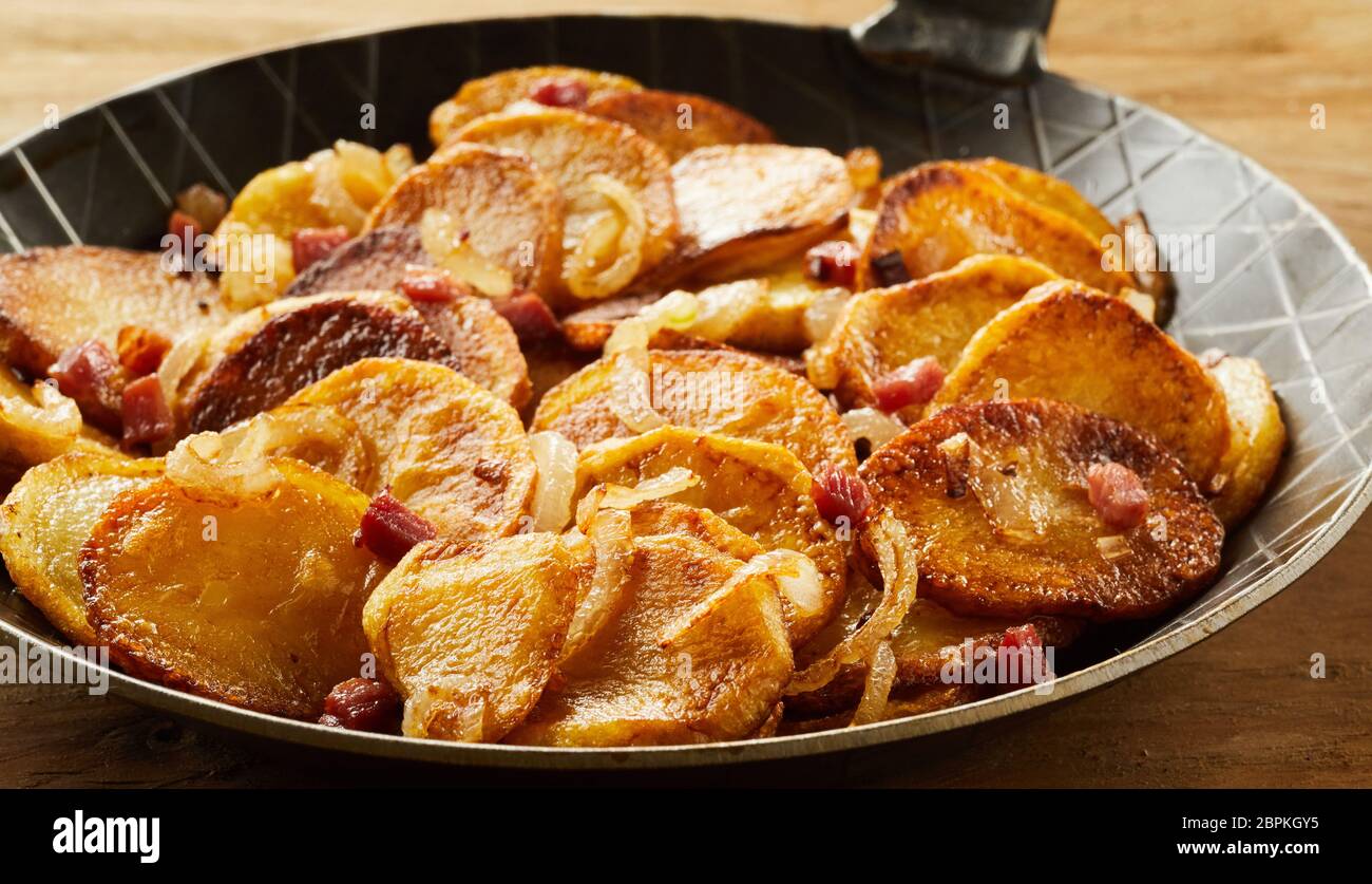 Knusprige Bratkartoffeln in einem schwarzen Skillet als Beilage in einem Restaurant serviert. Stockfoto