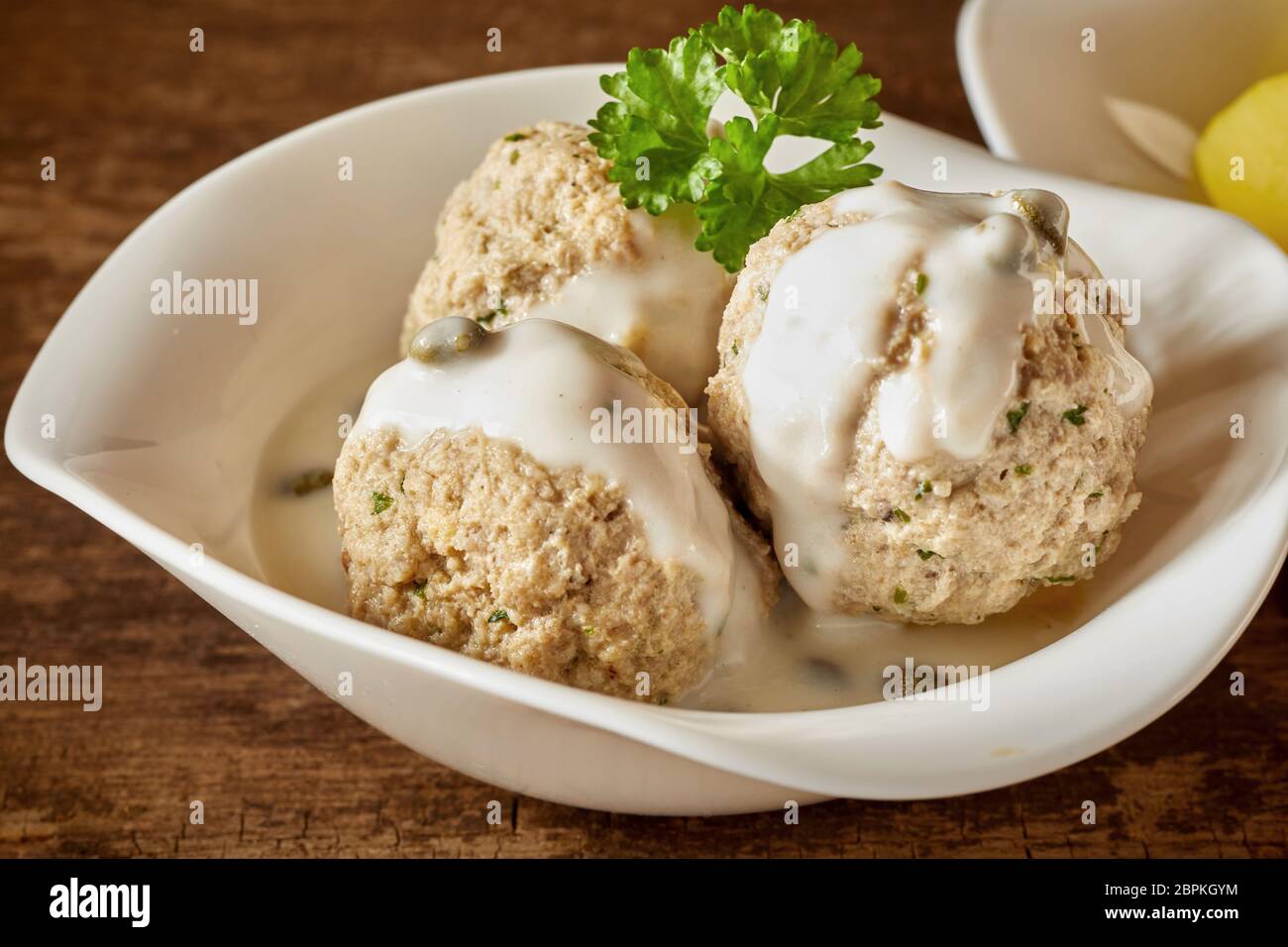 Drei bayerische Knödel in cremiger Sauce garniert mit Petersilie diente als Beilage zu einer Mahlzeit Stockfoto