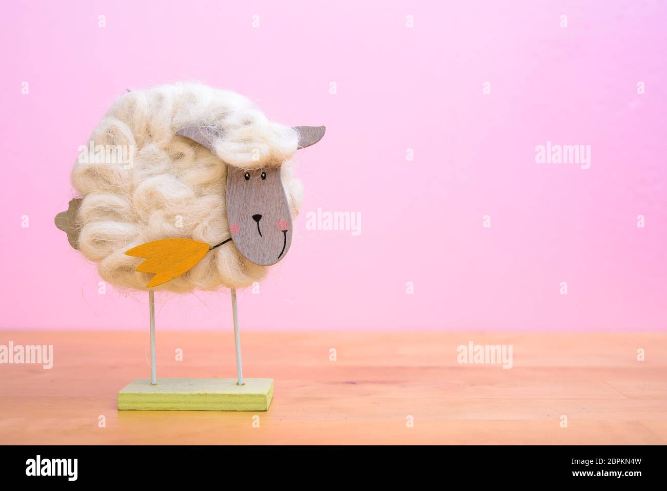 Lustige Schaf mit Blume vor rosa Hintergrund Stockfoto