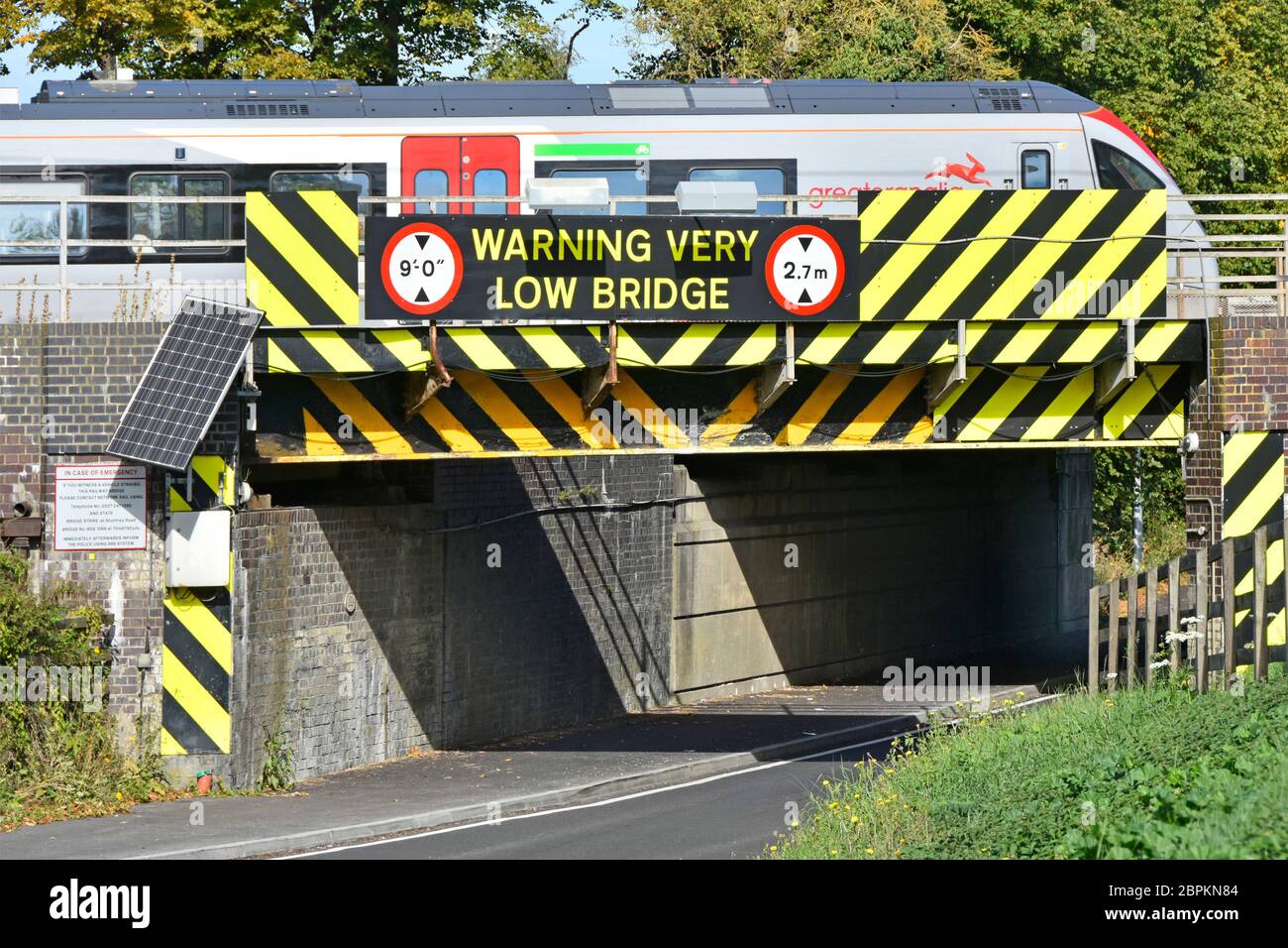 Mehr Anglia Personenzug fährt Ely Bahnhof Kreuzung low road bridge Warnmarkierungen Symbole & Warnschild Cambridgeshire England Großbritannien Stockfoto