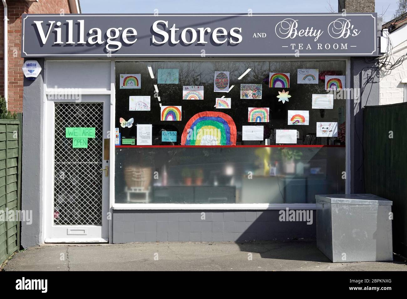 Village Store und Tea Room Shop Front mit Schaufenster der Kinder Regenbogen Kunst Poster Teil von Thank You NHS während Coronavirus Pandemie Großbritannien Stockfoto