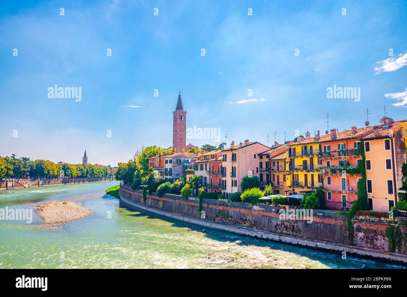 Verona Stadtbild mit Gebäuden auf der Böschung des Flusses Etsch, Glockenturm Campanile di Santa Anastasia katholische Kirche, historisches Stadtzentrum, blauer Himmel Hintergrund, Region Venetien, Norditalien Stockfoto