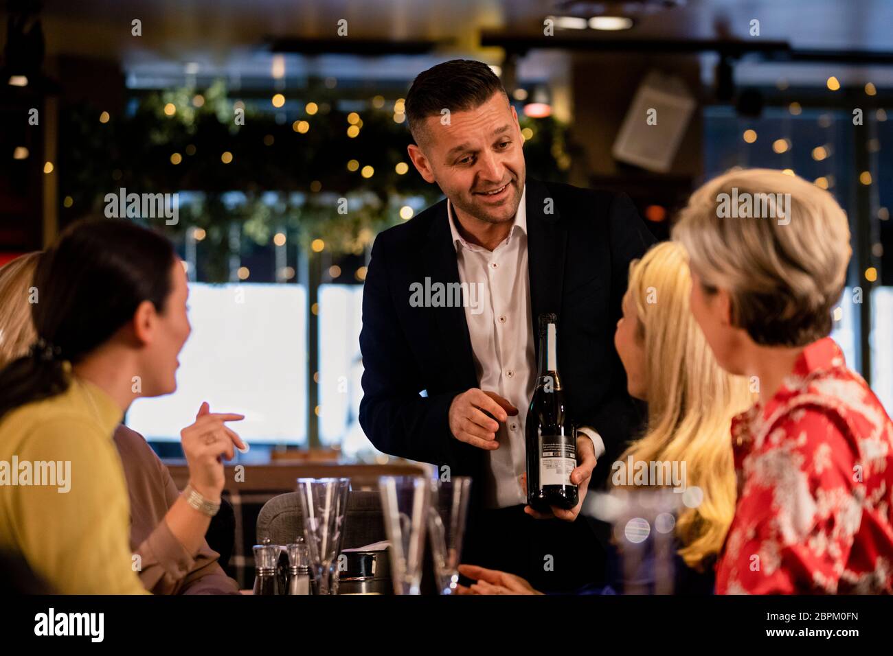 Reifen wiater Angebot und zeigt eine kleine Gruppe von reifen Frauen, welche Art von Prosecco Sie im Restaurant bieten. Stockfoto