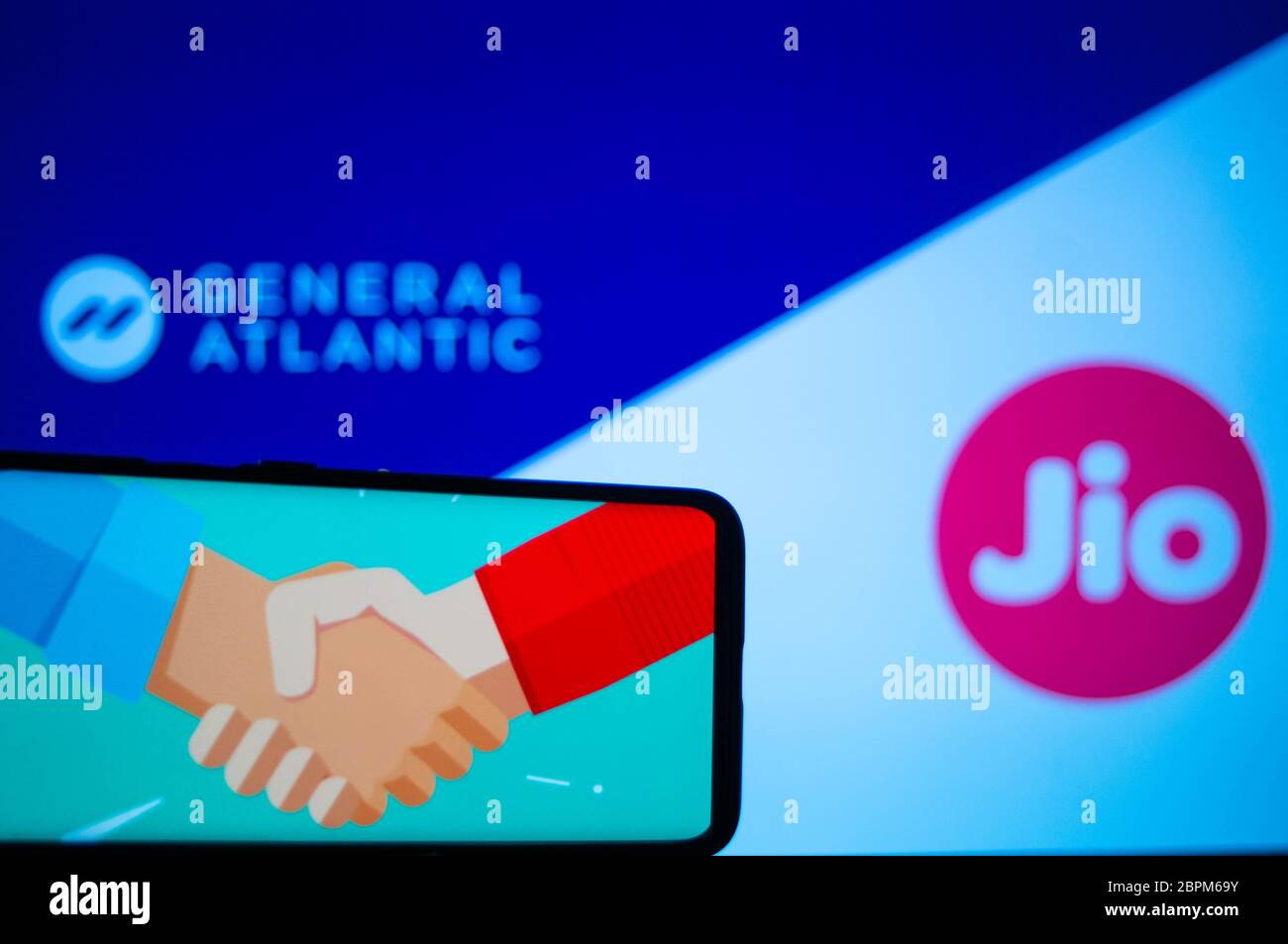 Jaipur, Indien, um 2020 - Foto eines Mobiltelefons mit einem Handschlag, was einen Deal bedeutet, mit General atlantic und Reliance jio im Hintergrund Stockfoto