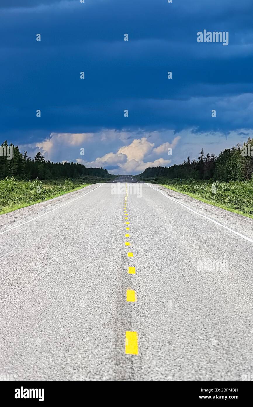 Die lange Sicht auf eine Autobahn mit einem Sturm in der Ferne. Stockfoto