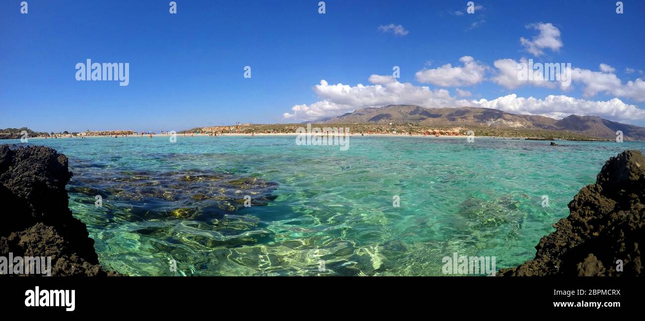 Elafonisi Strand im Süden der Insel Kreta mit Panoramablick über die Bergkette und das azurblaue Wasser in Griechenland Stockfoto