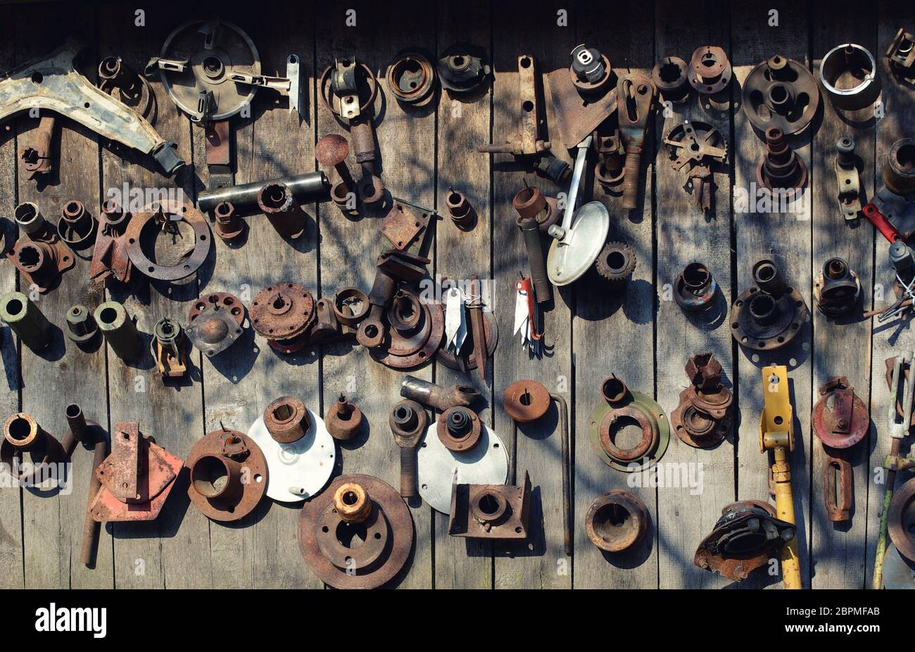 Vielen alten rostigen Auto Teile hängen an einer Holzwand. Grunge Hintergrund. Stockfoto