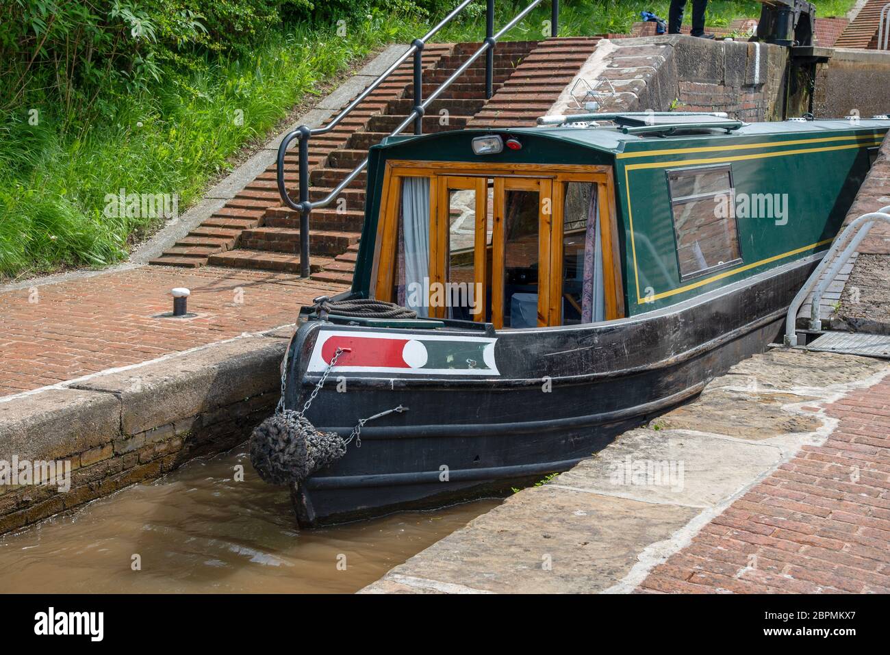 Grünes Schmalboot verlässt die mittlere Schleusenkammer der Grindley Brook Staircase Lock auf dem Llangollen Kanal. Stockfoto