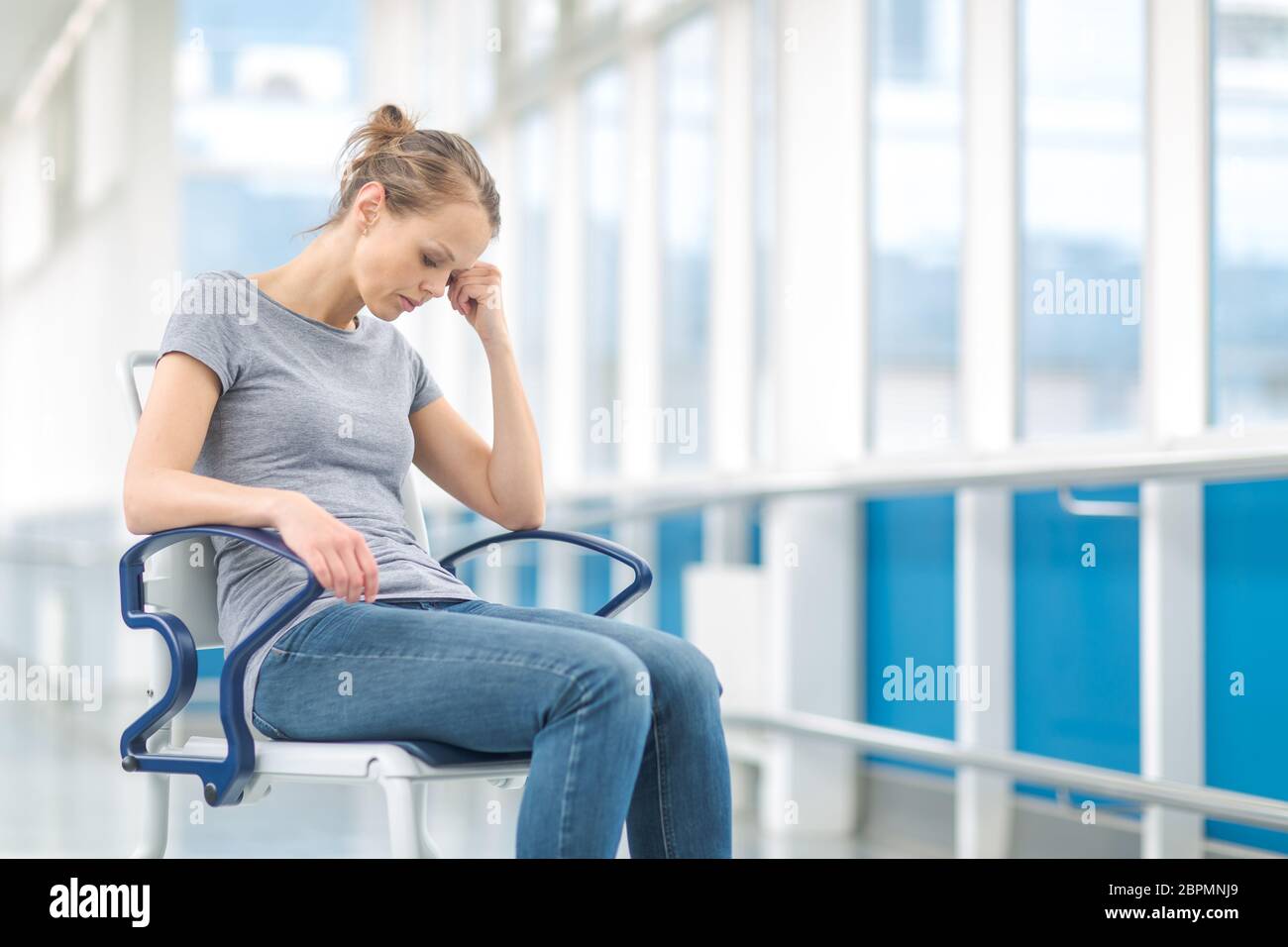 Weibliche Patienten und sitzt in einem Rollstuhl für Patienten Gefühl, nicht gut genug zu stehen, warten in einem modernen Krankenhaus (flacher Freiheitsgrade berücksichtigt werden. Stockfoto