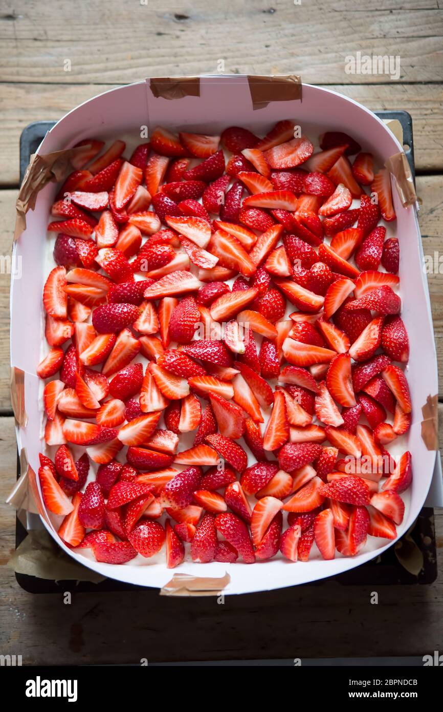 Zubereitung von Biskuitkuchen mit Sahne und Erdbeeren Stockfoto