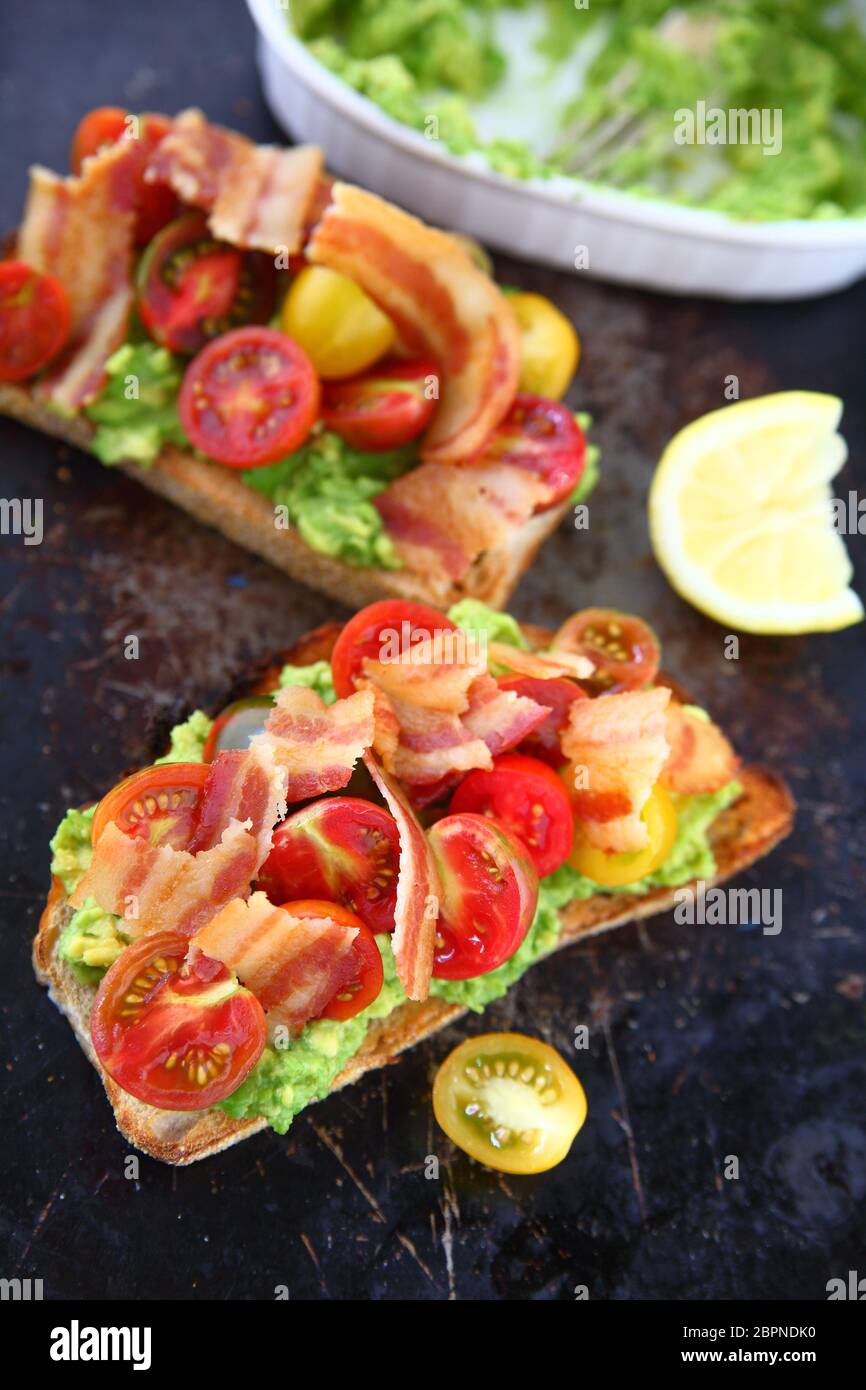 Speck und Kirschtomaten auf Toast mit Guacamole Stockfoto