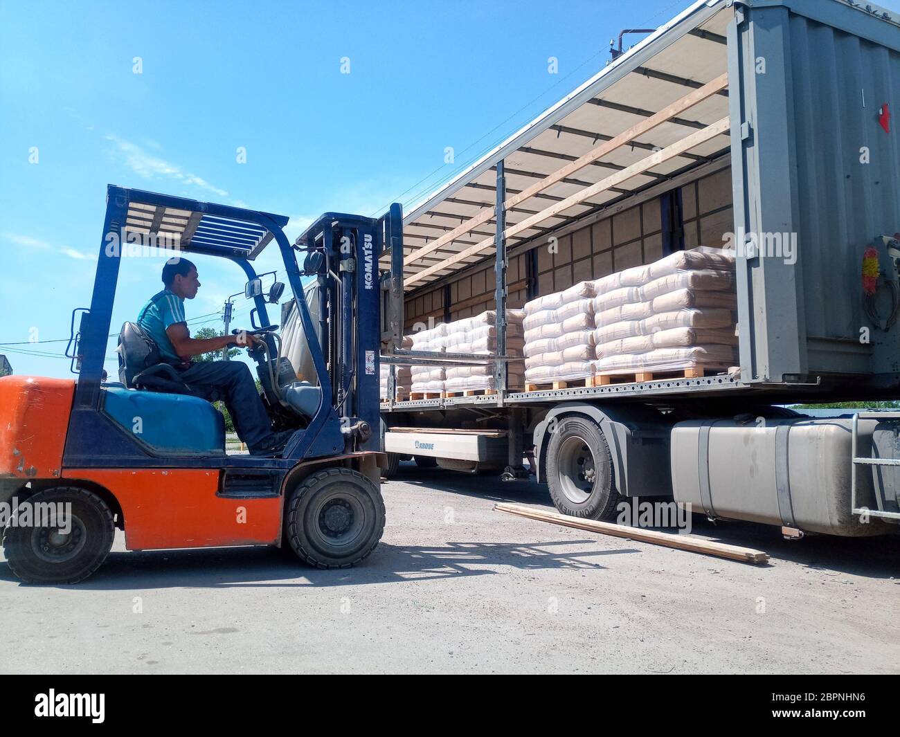 Krasnodar, Russland - 13. Juni 2019: Entladen von Säcken aus Zement von einem LKW mit einem Gabelstapler. Stockfoto