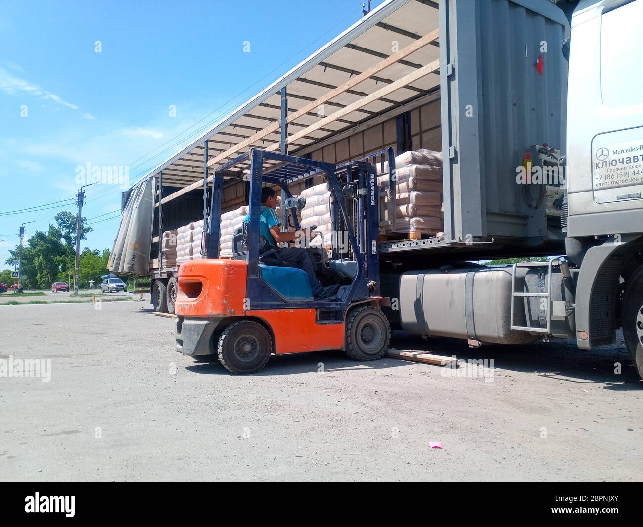 Krasnodar, Russland - 13. Juni 2019: Entladen von Säcken aus Zement von einem LKW mit einem Gabelstapler. Stockfoto