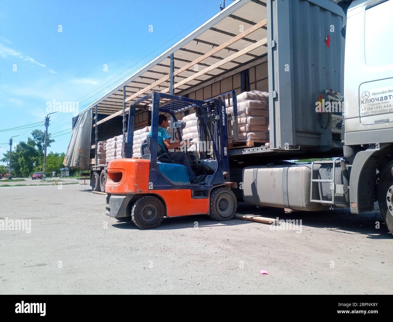 Krasnodar, Russland - 13. Juni 2019: Entladen von Säcken aus Zement von einem LKW mit einem Gabelstapler. Stockfoto