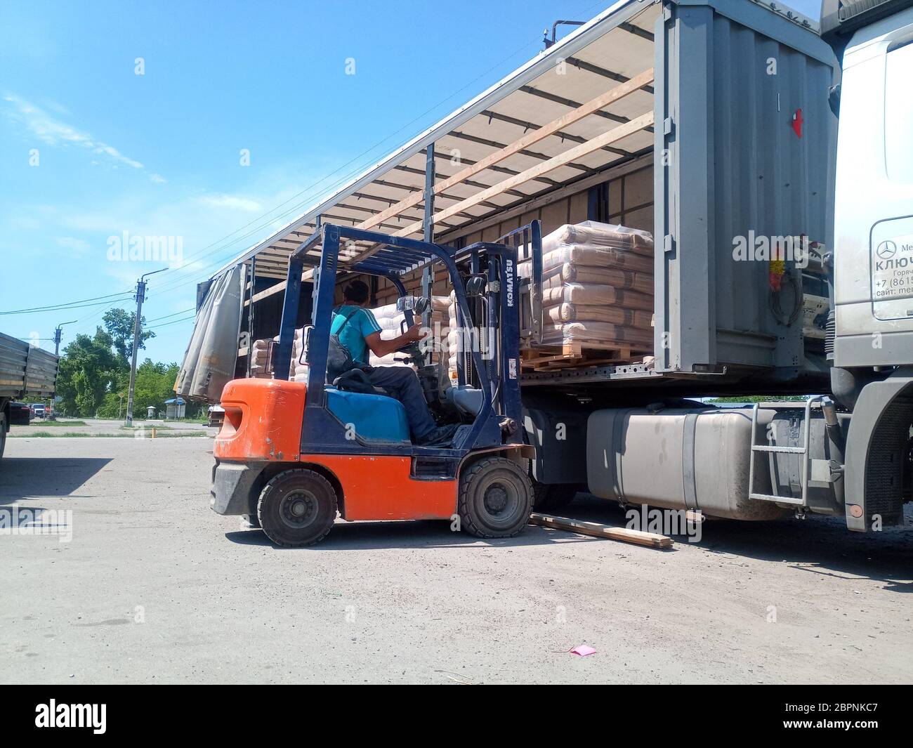 Krasnodar, Russland - 13. Juni 2019: Entladen von Säcken aus Zement von einem LKW mit einem Gabelstapler. Stockfoto