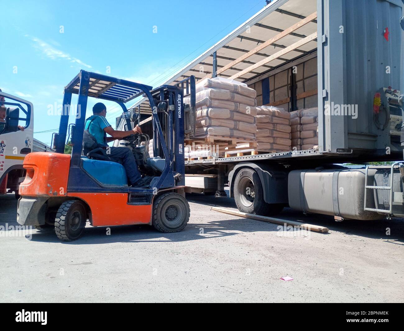 Krasnodar, Russland - 13. Juni 2019: Entladen von Säcken aus Zement von einem LKW mit einem Gabelstapler. Stockfoto