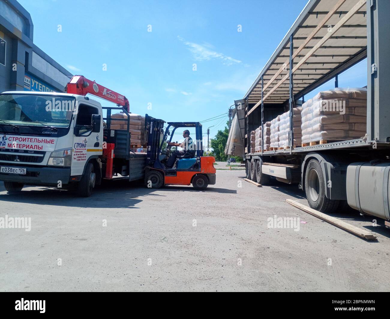 Krasnodar, Russland - 13. Juni 2019: Entladen von Säcken aus Zement von einem LKW mit einem Gabelstapler. Stockfoto