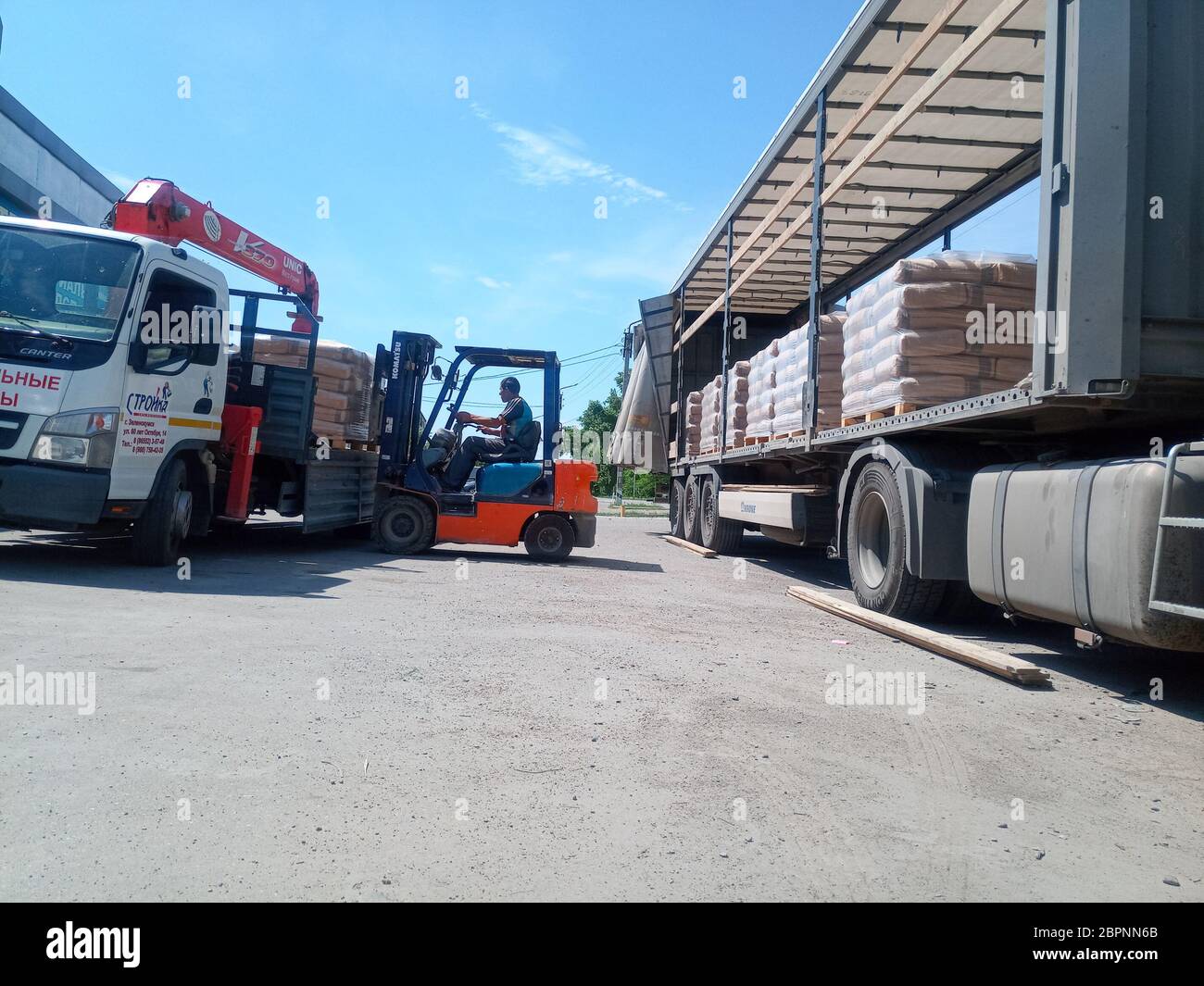 Krasnodar, Russland - 13. Juni 2019: Entladen von Säcken aus Zement von einem LKW mit einem Gabelstapler. Stockfoto