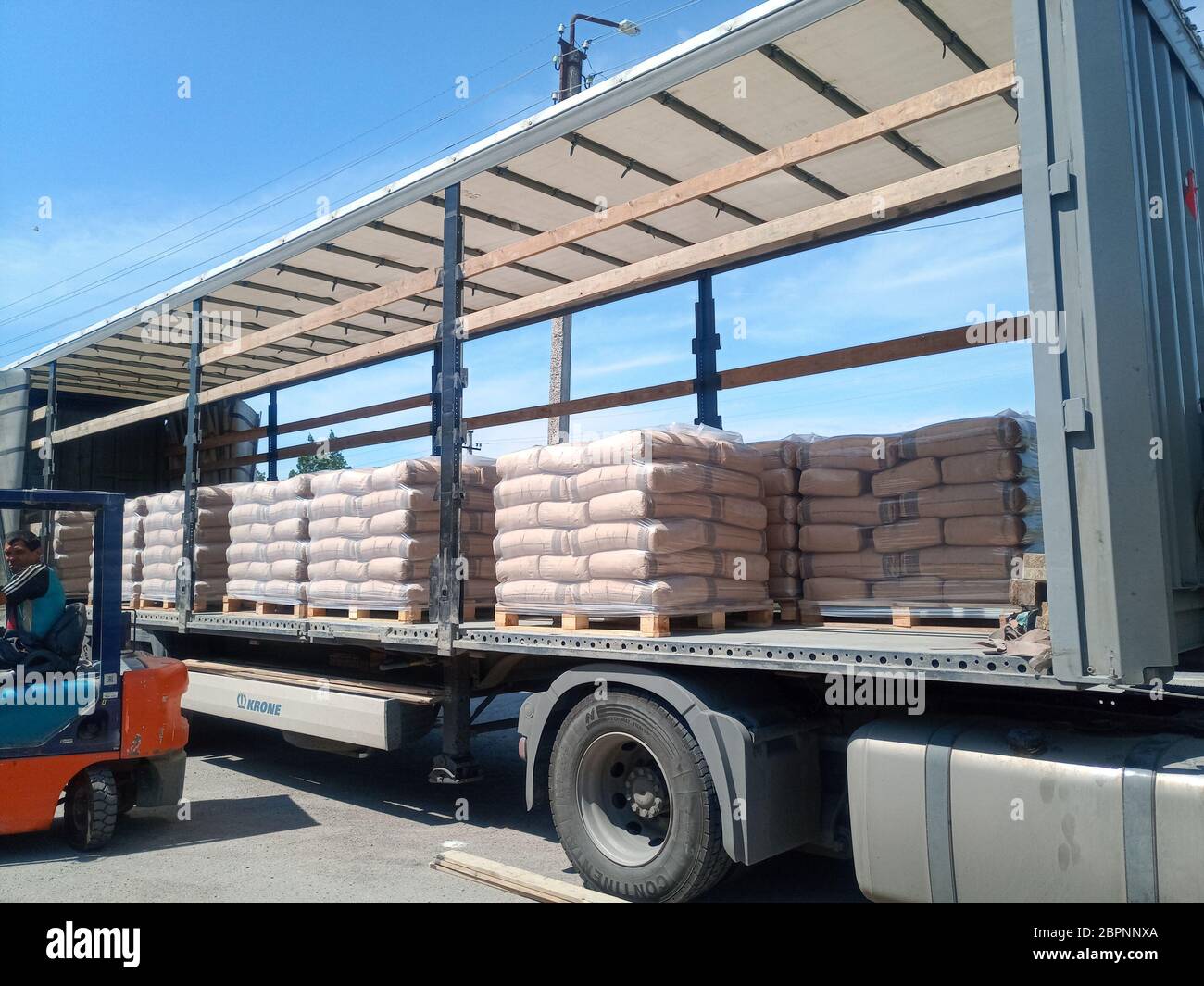 Krasnodar, Russland - 13. Juni 2019: Entladen von Säcken aus Zement von einem LKW mit einem Gabelstapler. Stockfoto