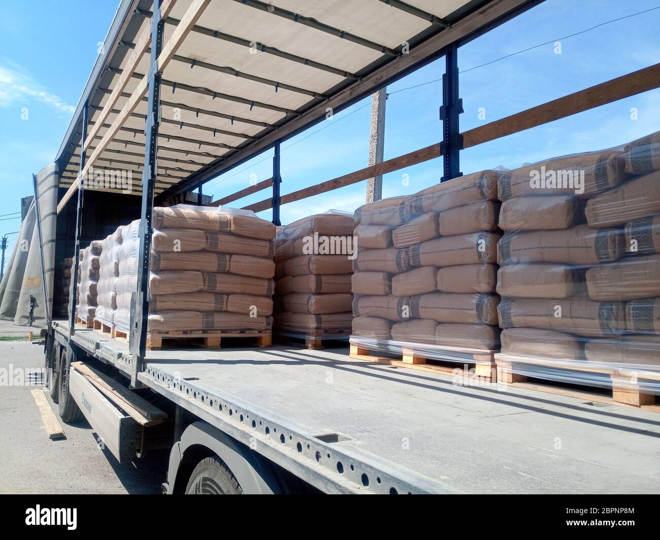 Krasnodar, Russland - 13. Juni 2019: Entladen von Säcken aus Zement von einem LKW mit einem Gabelstapler. Stockfoto