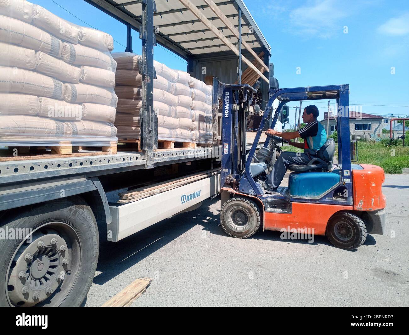 Krasnodar, Russland - 13. Juni 2019: Entladen von Säcken aus Zement von einem LKW mit einem Gabelstapler. Stockfoto