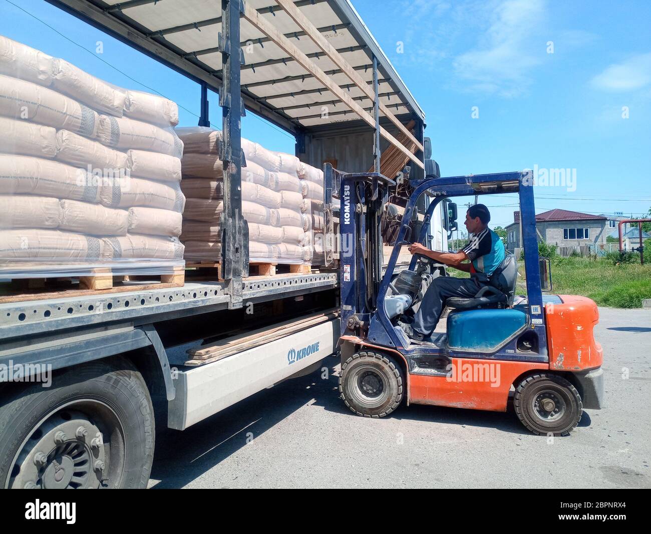 Krasnodar, Russland - 13. Juni 2019: Entladen von Säcken aus Zement von einem LKW mit einem Gabelstapler. Stockfoto