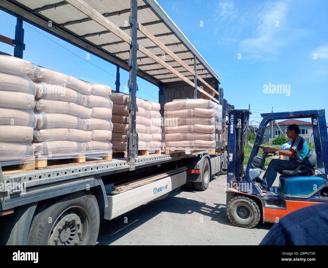 Krasnodar, Russland - 13. Juni 2019: Entladen von Säcken aus Zement von einem LKW mit einem Gabelstapler. Stockfoto
