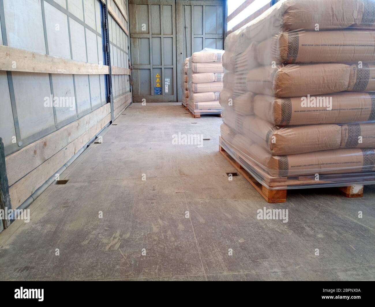 Krasnodar, Russland - 13. Juni 2019: Entladen von Säcken aus Zement von einem LKW mit einem Gabelstapler. Stockfoto