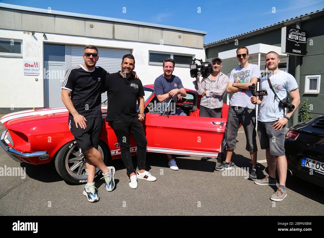 Lukas Podolski - Mustang - der deutsche Fußballspieler Lukas Podolski kommt sein neues Auto und Orkan Sahin - Oldtimer-Experte (rechts) Stockfoto