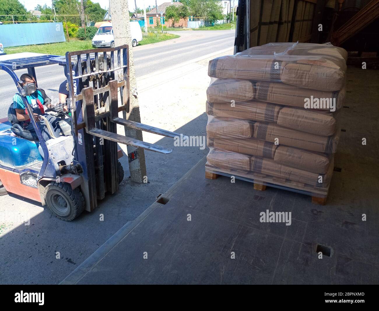 Krasnodar, Russland - 13. Juni 2019: Entladen von Säcken aus Zement von einem LKW mit einem Gabelstapler. Stockfoto